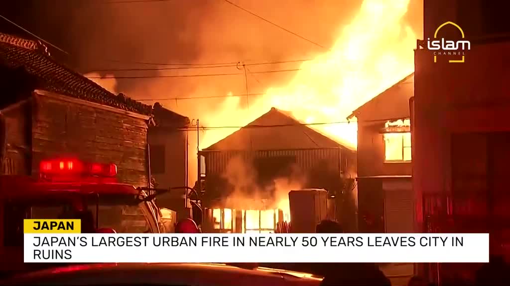 Flames engulf the rooftops of several buildings, casting an orange glow across the scene. The Islam Channel logo is visible, and the news report from Japan describes a devastating fire.
Flames engulf the rooftops of several buildings, casting an orange glow across the scene. The Islam Channel logo is visible, and the news report from Japan describes a devastating fire.