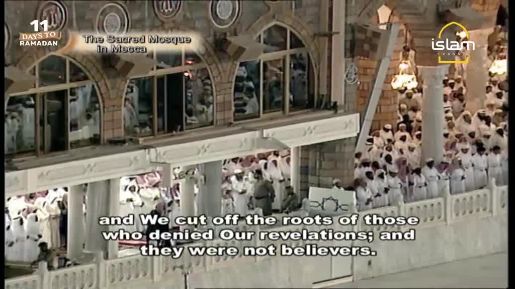 A crowd of people in white robes stands in prayer at the Sacred Mosque in Mecca. The Islam Channel logo is visible in the upper right corner.