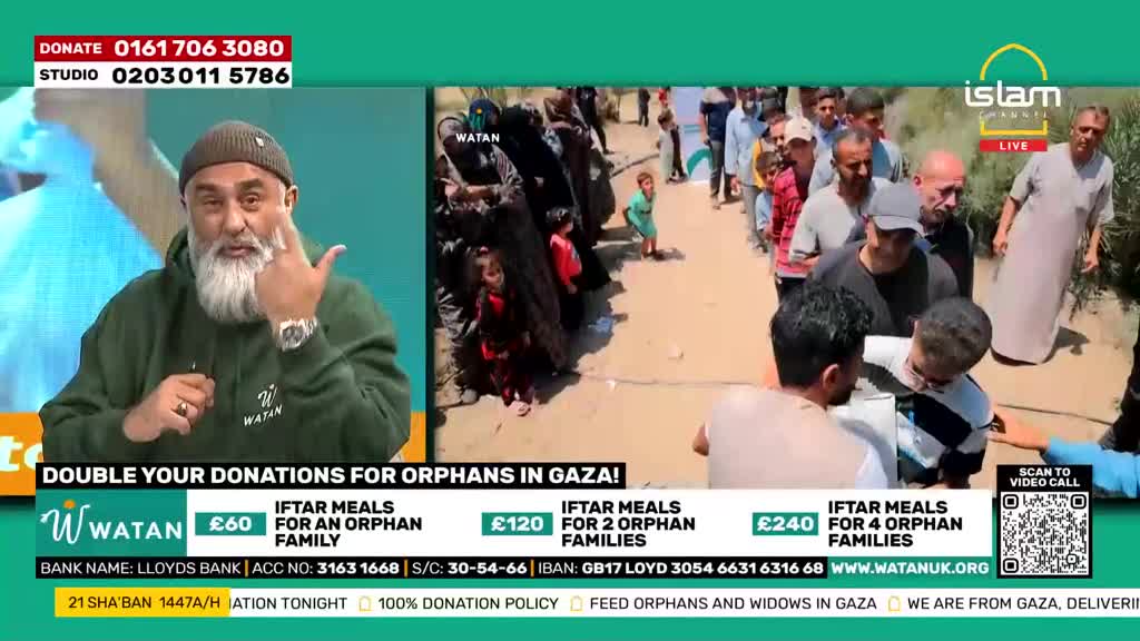 A man with a grey beard gestures with his hand as he speaks on a green screen. Behind him, a line of people, including children, waits patiently in what appears to be a dusty outdoor setting.