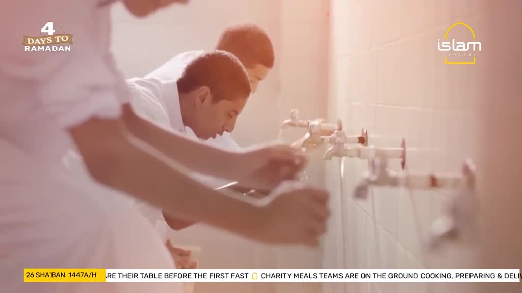 Boys in white tunics lean over a row of taps, washing their hands. The water runs clear as they prepare for Ramadan.