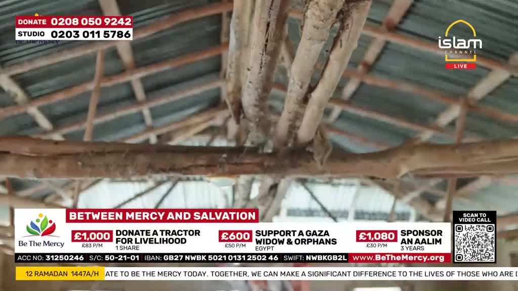 The rough-hewn wooden beams of a simple roof stretch overhead. Below, a banner displays donation options for "Be The Mercy," an organisation working with Islam Channel.