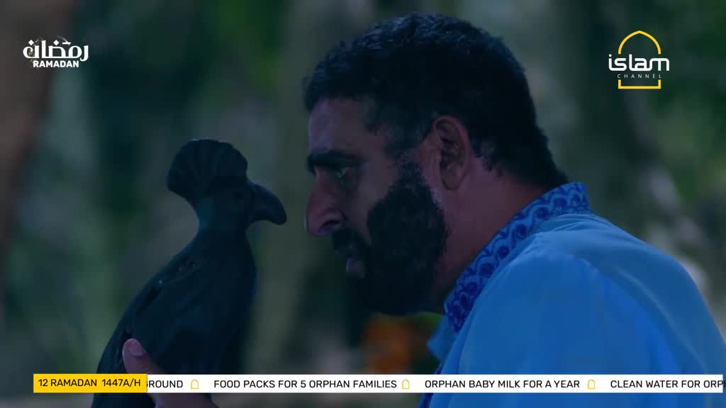 A man with a dark beard leans in to examine a black, bird-shaped carving. The Islam Channel logo is visible in the upper right corner.