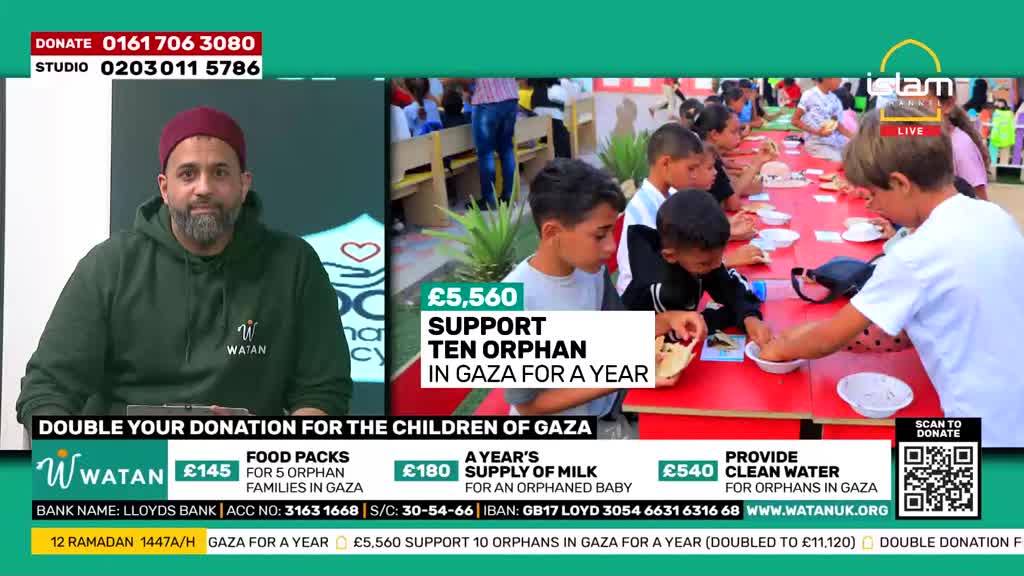 Children are gathered around a long red table, eating from bowls. A man in a green hoodie and a red cap speaks directly to the camera.