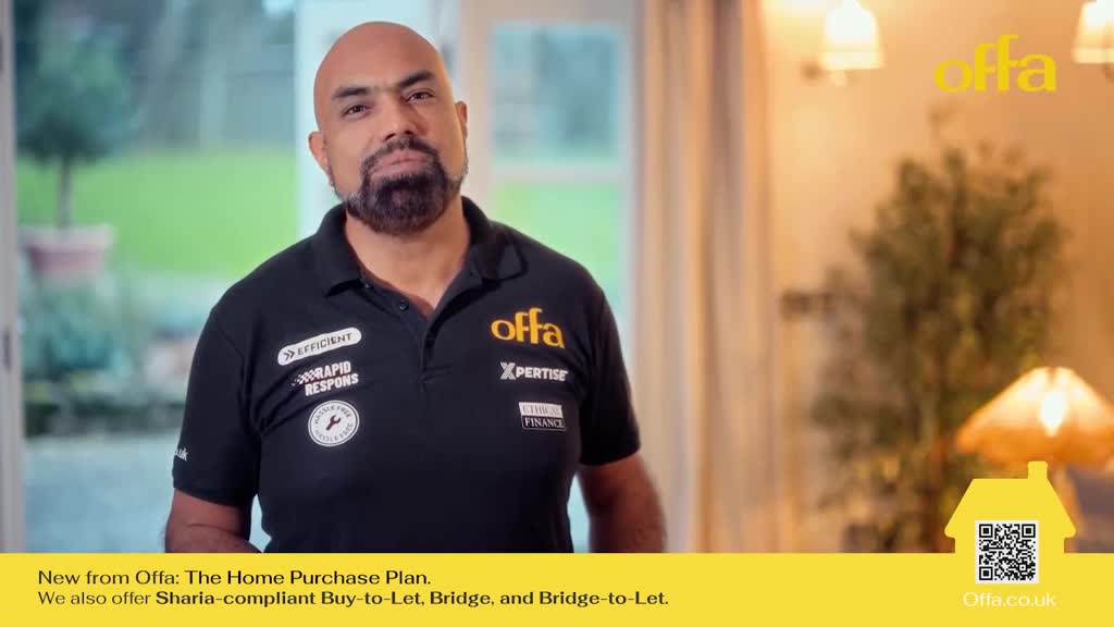 A man in a black polo shirt with company logos stands looking directly ahead. The Islam Channel logo is visible on his shirt.