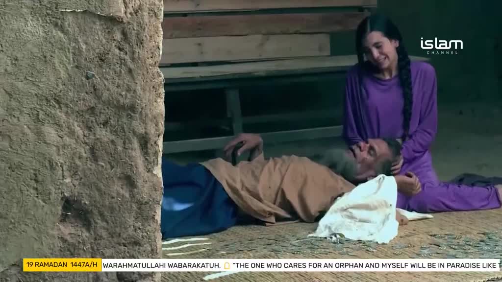 A young woman in a purple tunic kneels beside an elderly man lying on the floor, her hand gently supporting his head. The scene, broadcast by Islam Channel, captures a moment of tender care.