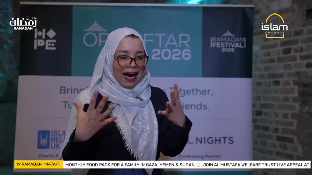 A woman in a hijab speaks animatedly, her hands gesturing. Behind her, banners announce "Ramadan Festival 2026" and "Islam Channel."