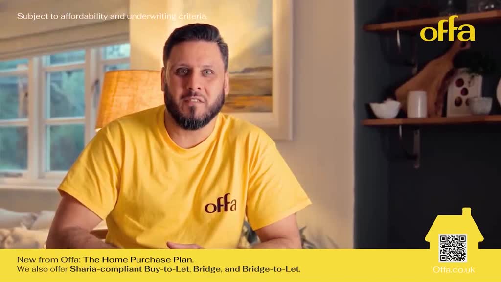 A man in a bright yellow t-shirt with "offa" printed on it speaks directly to the camera. Behind him, a window looks out onto a leafy garden. A man in a bright yellow t-shirt with "offa" printed on it speaks directly to the camera. Behind him, a window looks out onto a leafy garden.