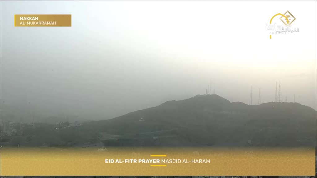 The sky over Makkah is hazy, obscuring the tops of the mountains dotted with communication towers. Below, the Masjid al-Haram is likely preparing for the Eid al-Fitr prayer. The sky over Makkah is hazy, obscuring the tops of the mountains dotted with communication towers. Below, the Masjid al-Haram is likely preparing for the Eid al-Fitr prayer.