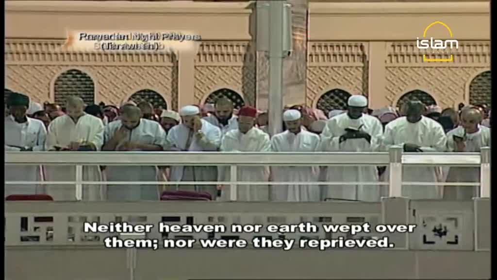 A group of men in white robes stand in prayer behind a railing. The Islam Channel logo appears in the upper right corner.