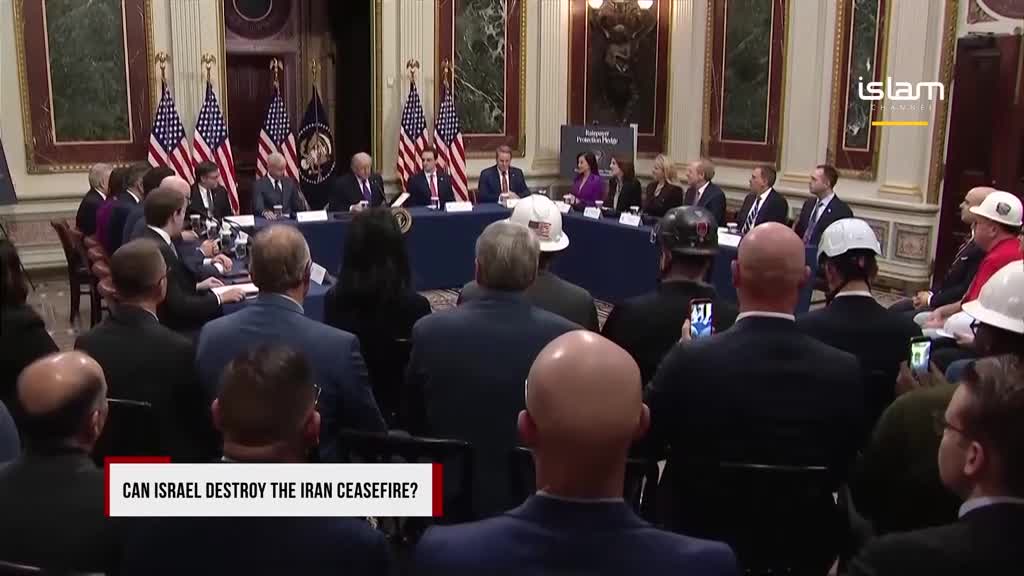 A panel of men in suits sit behind a long table, facing a crowd. Several people in the audience are holding up their phones, capturing the event for Islam Channel. A panel of men in suits sit behind a long table, facing a crowd. Several people in the audience are holding up their phones, capturing the event for Islam Channel.