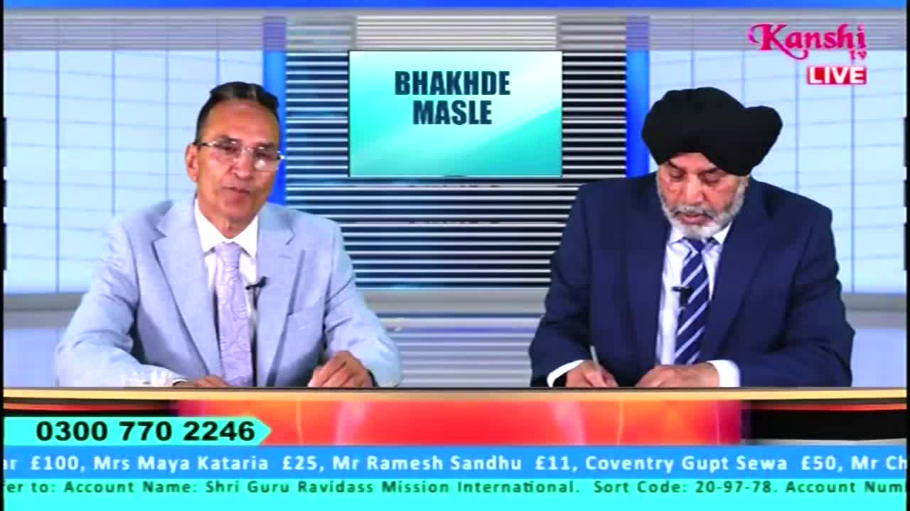 Two men in suits sit behind a desk on a Kanshi TV set, with the words "BHAKHDE MASLE" displayed on a screen behind them. One man speaks, while the other looks down at papers.
