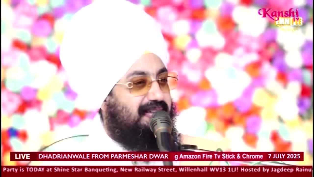 A man in a white turban and gold-rimmed glasses speaks into a microphone, the Kanshi TV logo visible in the corner. The broadcast, live from the United Kingdom, is being streamed on Amazon Fire TV.
