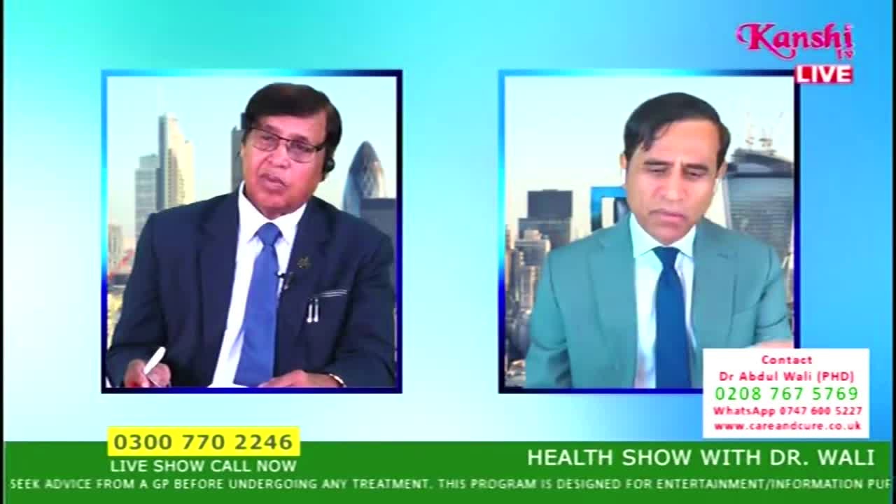Two men in suits are framed on a Kanshi TV screen, both in separate boxes against a backdrop of the United Kingdom. One man gestures with a pen, while the other listens intently.
