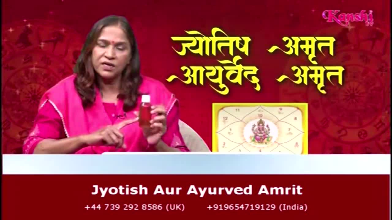 On Kanshi TV, a woman in a pink outfit gestures with a small bottle of liquid. The show, "Jyotish Aur Ayurved Amrit," is broadcasting from the United Kingdom and India.

