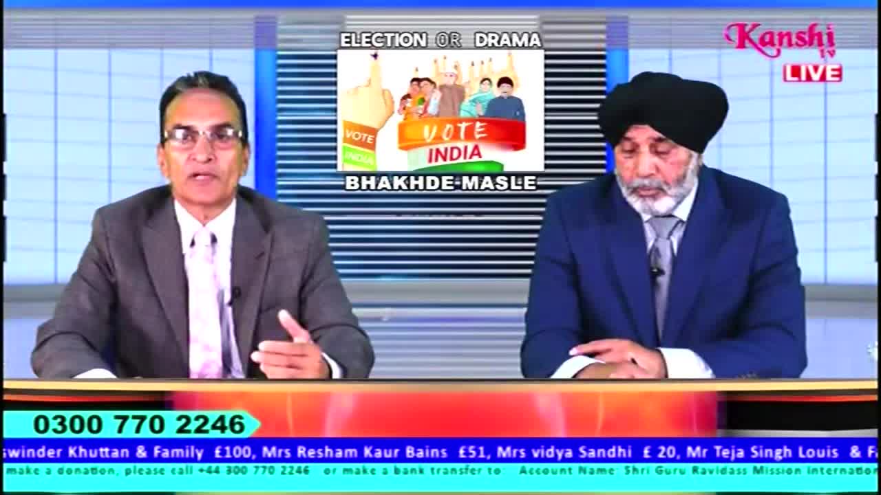 Two men in suits sit behind a desk, discussing "Election or Drama" on Kanshi TV. The man on the left gestures with his right hand while speaking, and the man on the right sits quietly.
