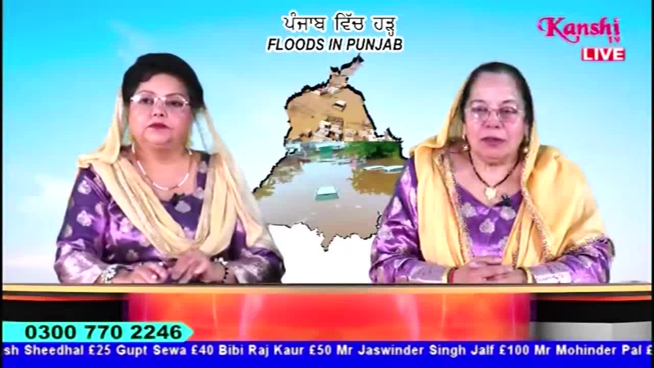 Two women in traditional attire sit at a desk, framed by a backdrop showing a map of Punjab and images of flooding. The Kanshi TV logo is visible, and a phone number scrolls at the bottom of the screen.
