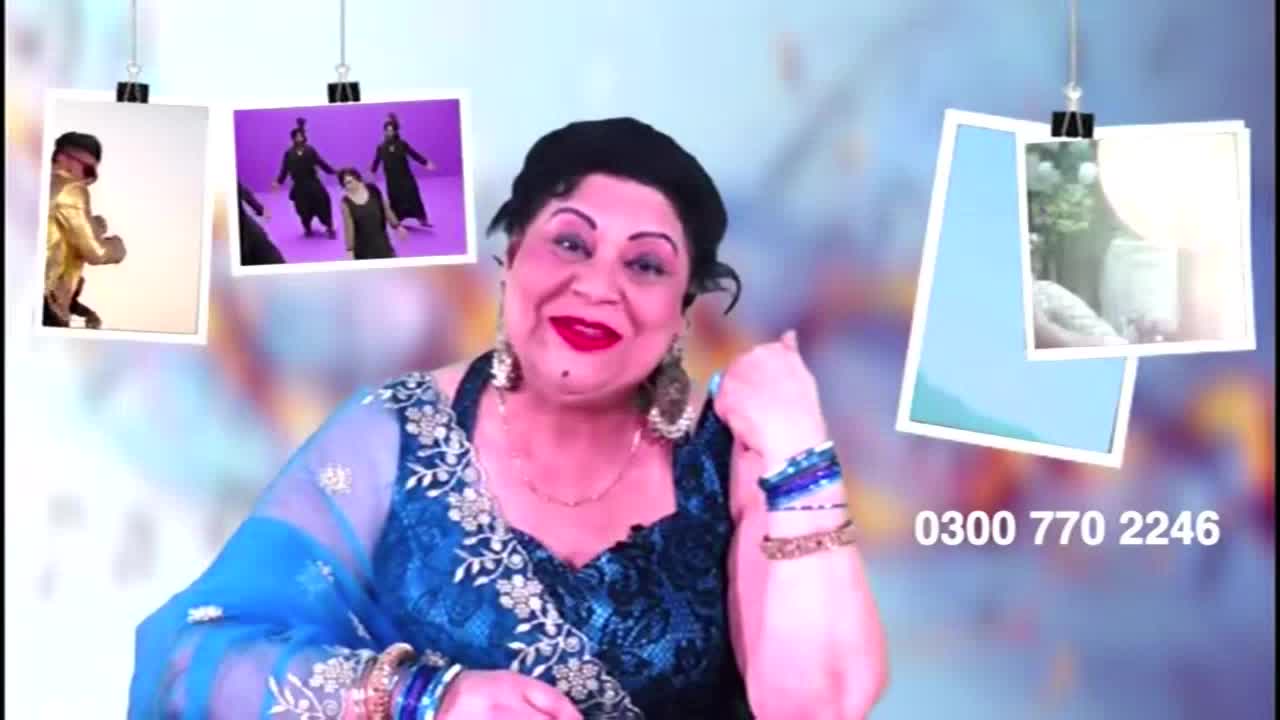 A woman in a blue sari smiles directly at the camera, framed by hanging photos. The Kanshi TV logo is absent, but a phone number is visible in the lower right corner.
