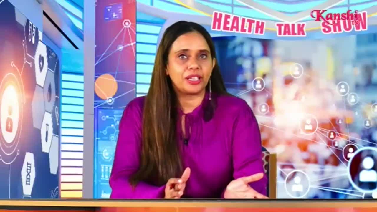 A woman in a bright purple top speaks animatedly, her hands gesturing as she talks. Behind her, graphics of connected people and medical symbols fill the screen, with "HEALTH TALK SHOW" and the Kanshi TV logo visible.