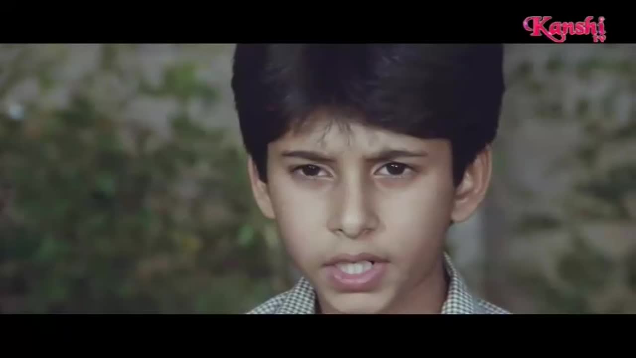 A young boy with dark hair looks directly ahead, his mouth slightly open. The Kanshi TV logo appears in the top right corner.