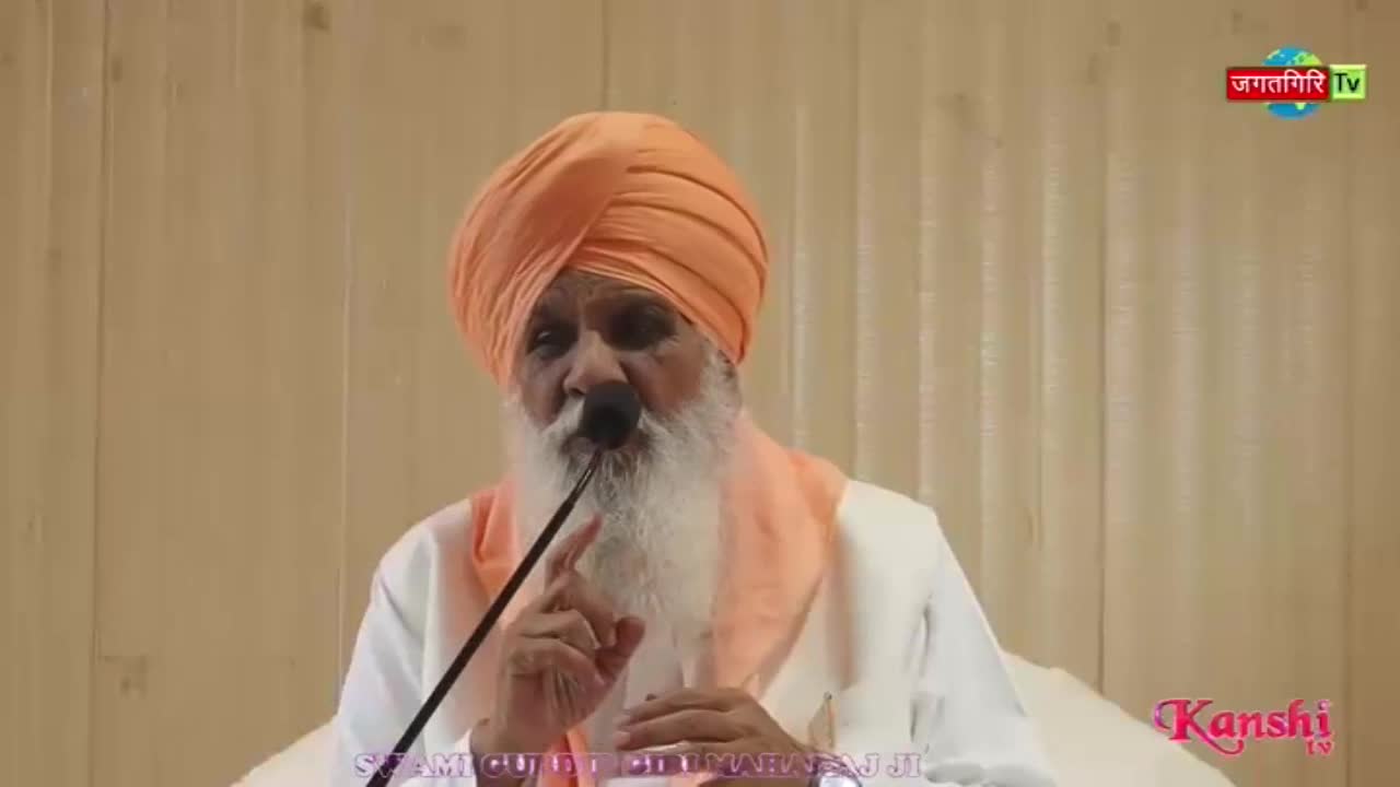 An older man with a long white beard and an orange turban speaks into a microphone. A logo for Kanshi TV appears in the corner.