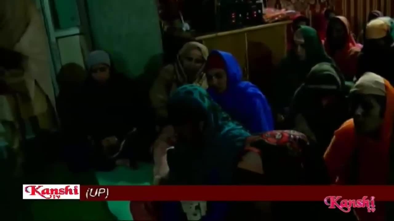 A group of people are gathered, some wearing headscarves and traditional clothing. A Kanshi TV chyron is visible at the bottom of the screen. A group of people are gathered, some wearing headscarves and traditional clothing. A Kanshi TV chyron is visible at the bottom of the screen.