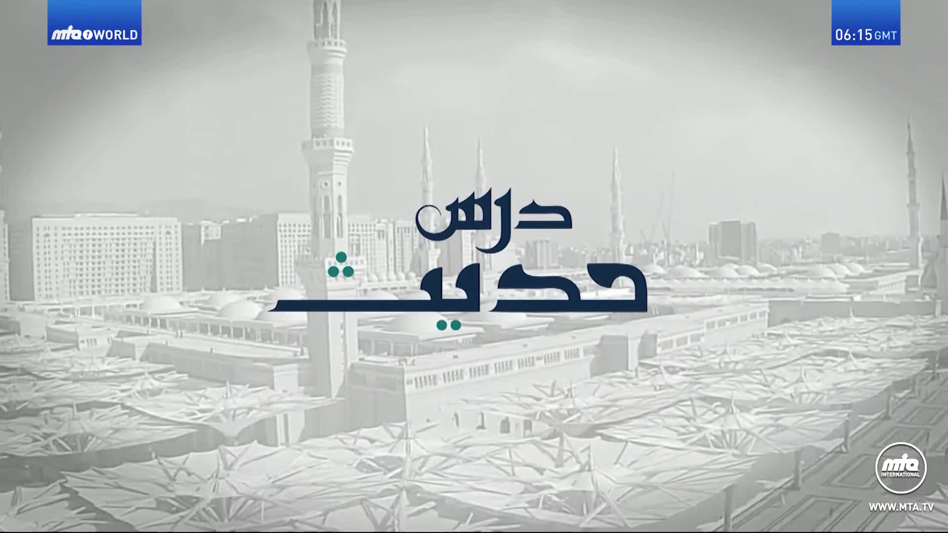 The MTA1 World logo sits in the corner as a title card displays Arabic script over a digitally rendered cityscape. The time in the United Kingdom is 06:15 GMT.
