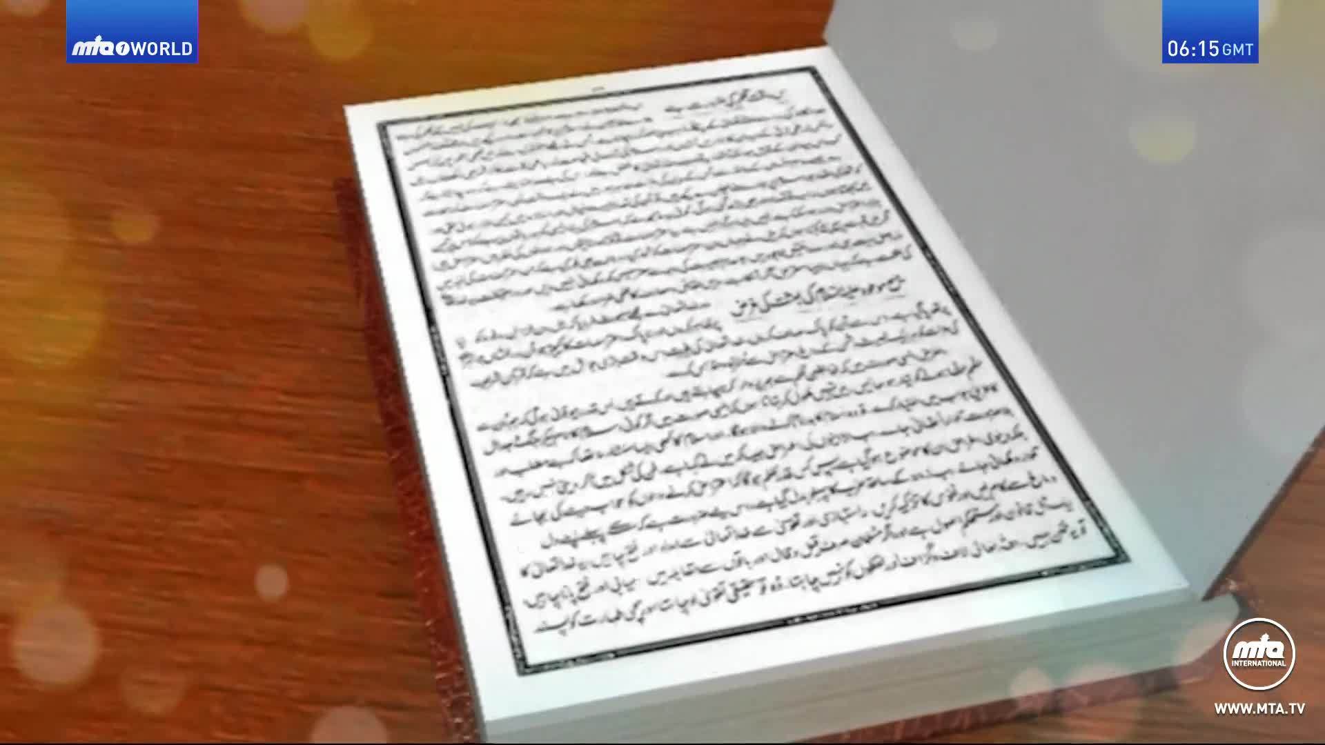 An open book, its pages filled with script, rests on a wooden surface. The MTA1 World logo is visible in the corner, and the time is 06:15 GMT.
