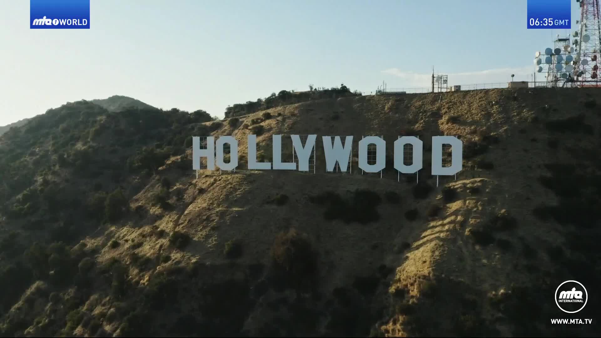 The iconic Hollywood sign stands stark white against the hillside.  It's a clear, sunny morning, and the time is 06:35 GMT, as indicated by the MTA1 World broadcast.
