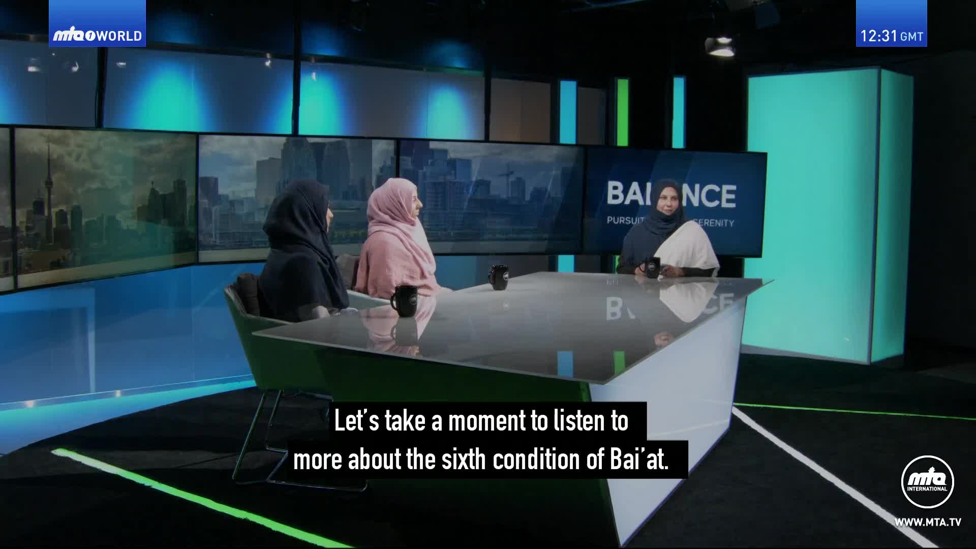 Three women in headscarves sit around a table in a studio, facing the camera. The screen behind them displays the word "BALANCE" and a cityscape, all under the MTA World logo.
