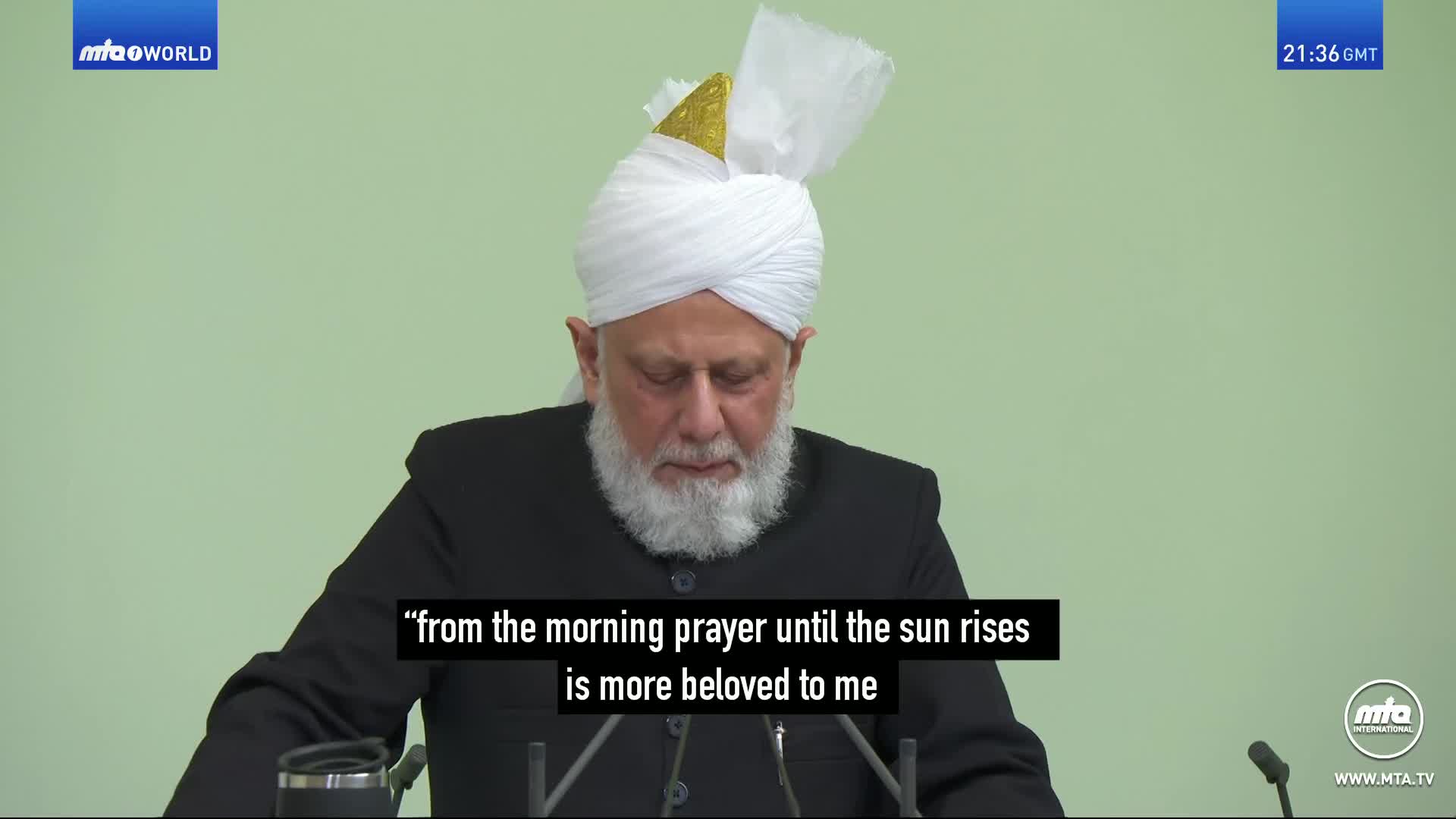 The man in the white turban is speaking, his gaze lowered. A caption below him reads, "from the morning prayer until the sun rises is more beloved to me." The man in the white turban is speaking, his gaze lowered. A caption below him reads, "from the morning prayer until the sun rises is more beloved to me."