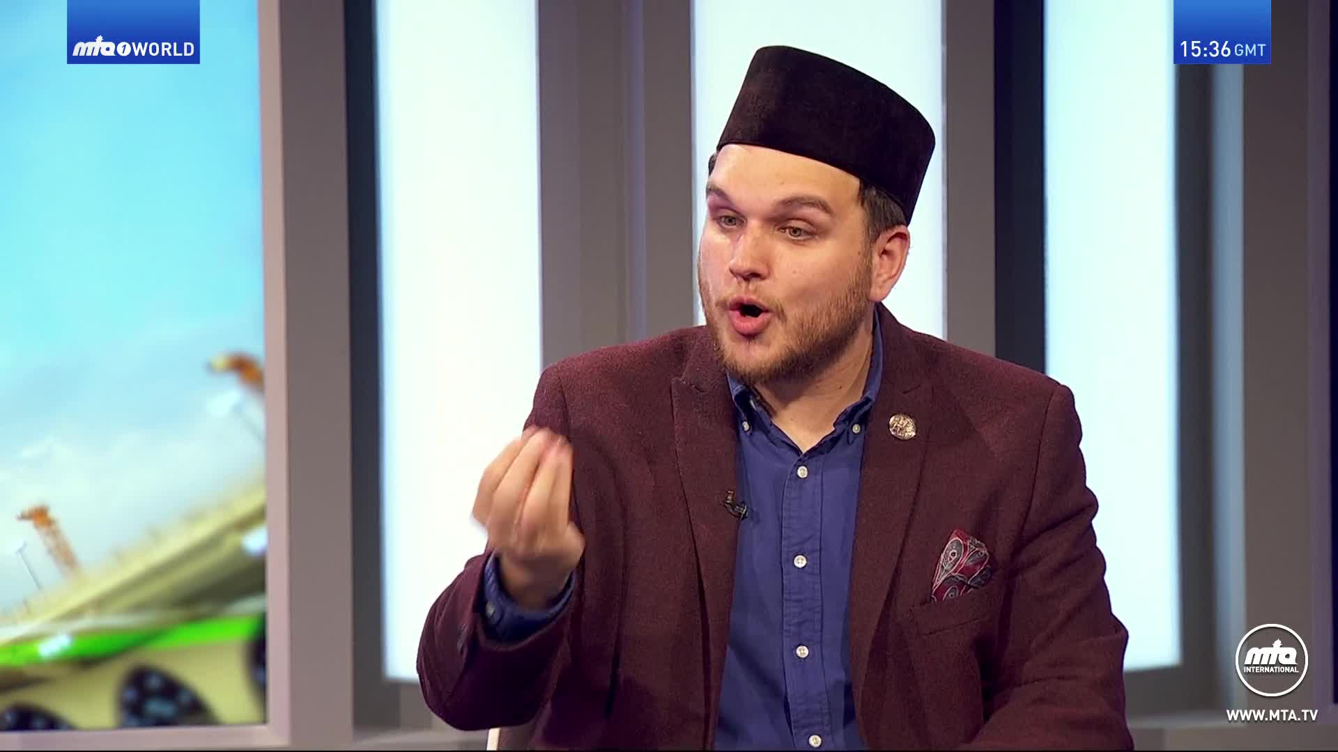 A man in a maroon jacket and a black kufi gestures with his hands while speaking. The MTA World logo appears in the upper left corner of the screen. A man in a maroon jacket and a black kufi gestures with his hands while speaking. The MTA World logo appears in the upper left corner of the screen.