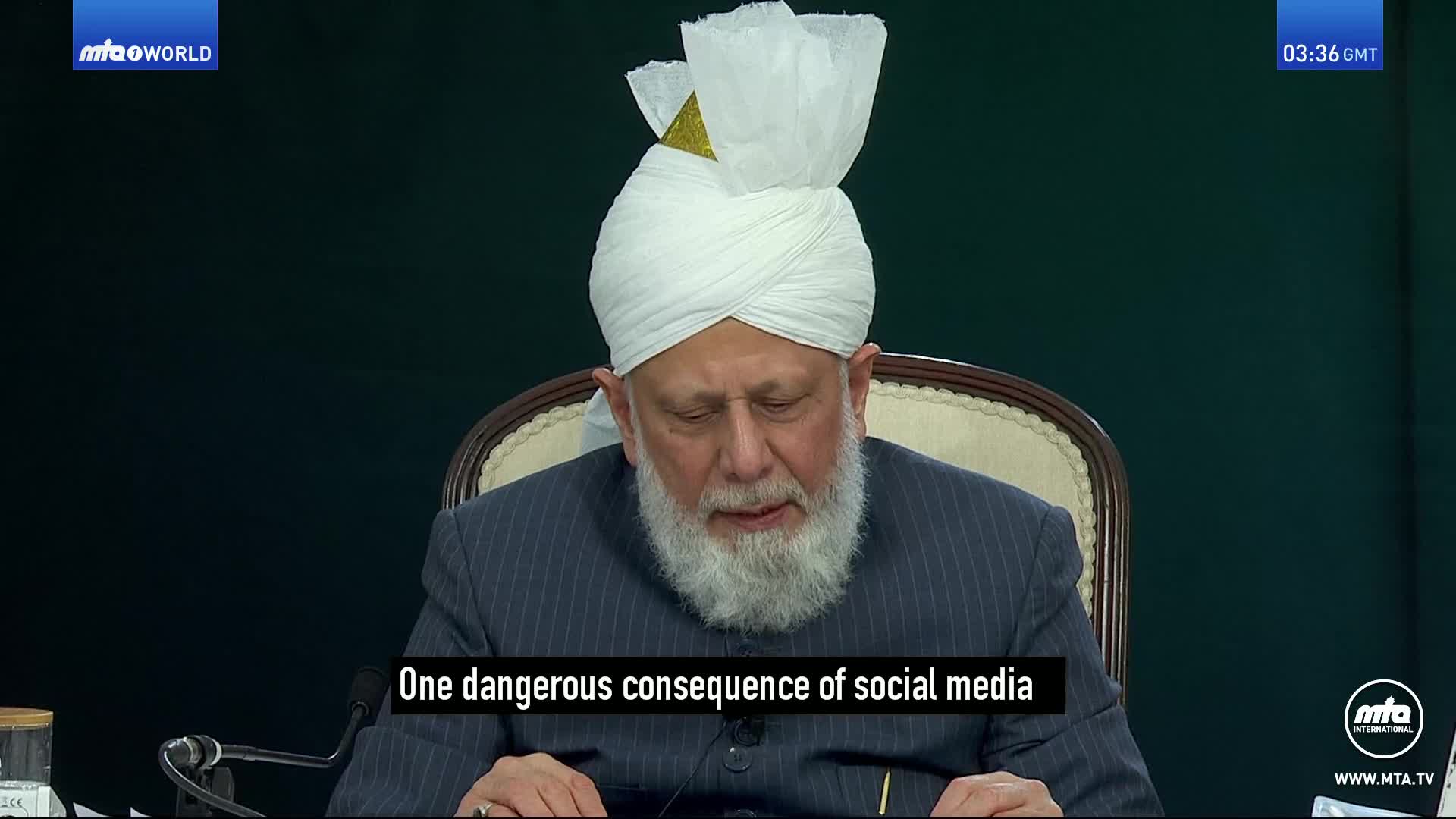 A man with a white turban and a long grey beard speaks, his gaze directed downwards. The text on screen reads "One dangerous consequence of social media." A man with a white turban and a long grey beard speaks, his gaze directed downwards. The text on screen reads "One dangerous consequence of social media."