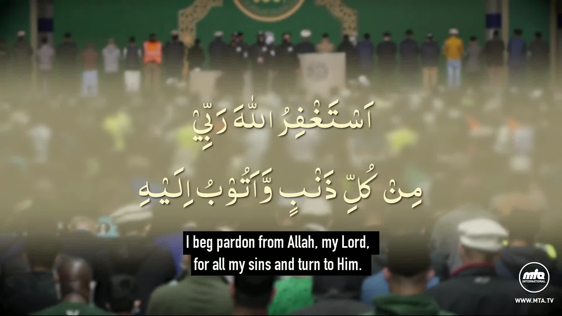 A crowd of people are gathered, some wearing prayer caps, with Arabic script displayed over them. The scene appears to be from an event broadcast by MTA World.