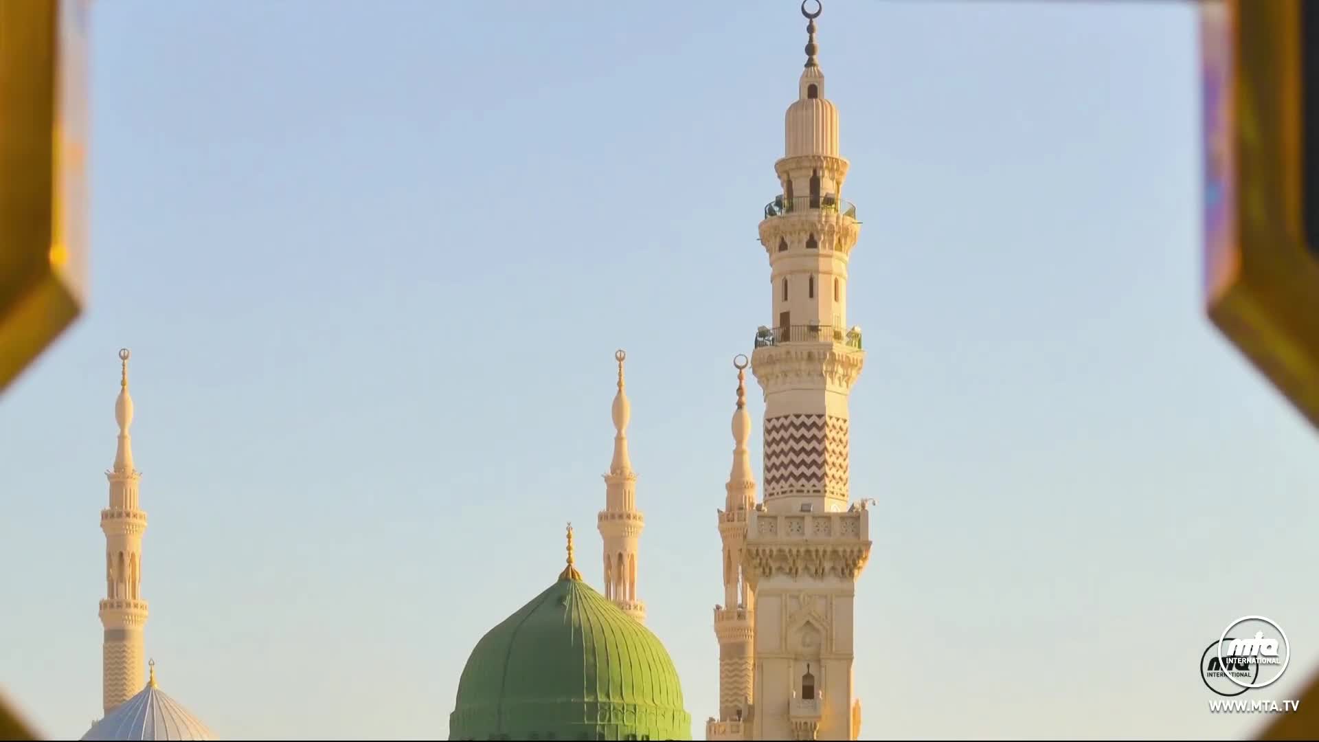 The sun casts a warm glow on the minarets and the green dome of the mosque. A golden frame, perhaps from a window or archway, partially encloses the scene.
