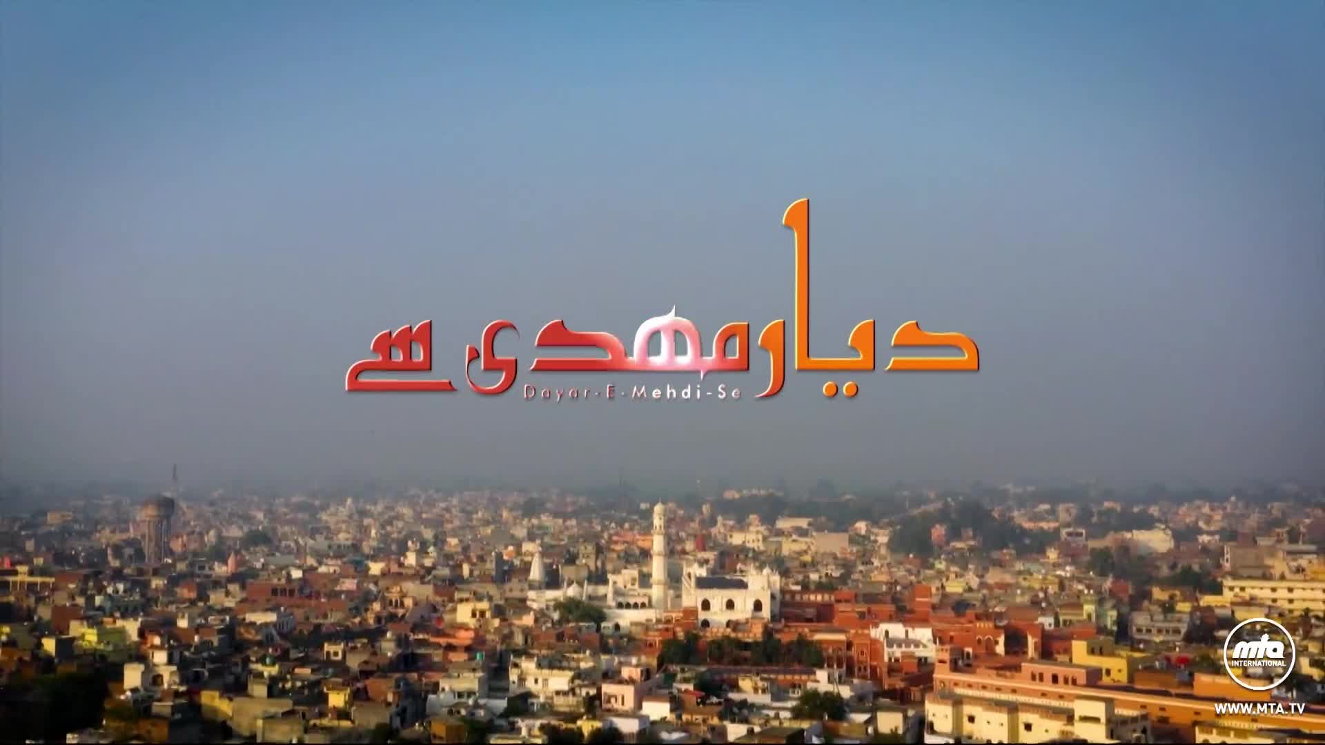 The sun casts a warm glow over a sprawling city, its buildings a mix of muted earth tones and white structures. Arabic script, bold and colorful, floats above the urban landscape.