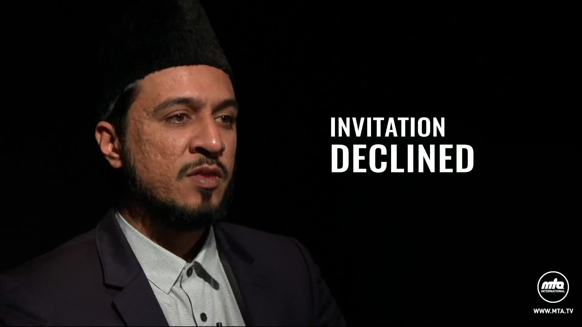 A man in a dark suit and a tall, black, brimless hat speaks directly to the camera. White text overlays the right side of the screen, reading "INVITATION DECLINED."