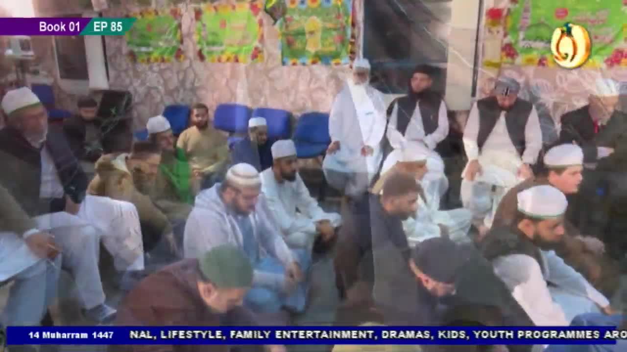 A group of men, most wearing white caps, sit attentively in a room. The Noor TV logo is visible, as is the "Book 01 EP 85" banner.
