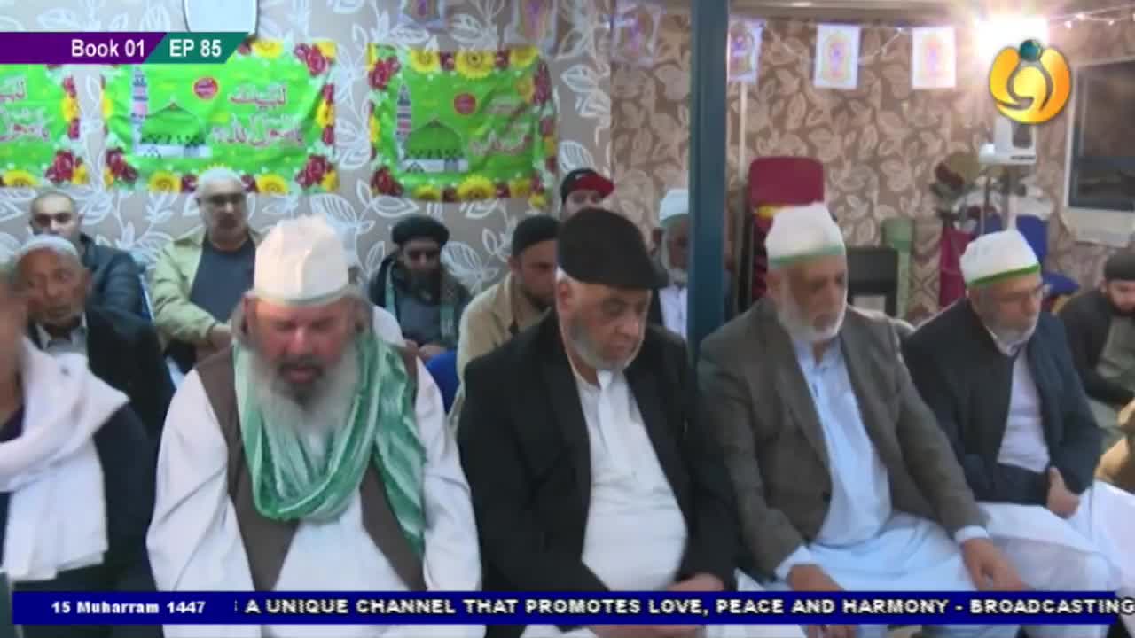 Men in white caps and long beards are seated, facing forward, some with their hands resting in their laps. A Noor TV logo is visible in the upper right corner, and the broadcast is from the United Kingdom.
