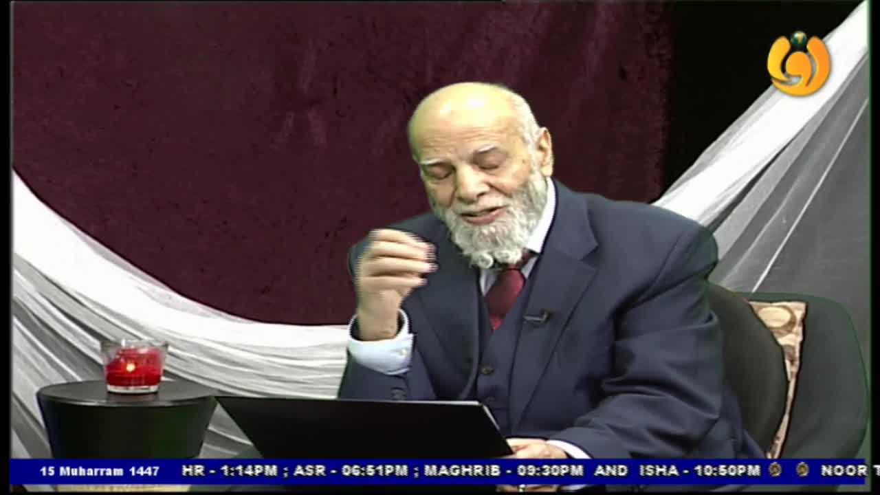 A man in a suit gestures with his right hand, speaking into a camera. A small candle burns on a table to his left, and the Noor TV logo is visible in the corner.
