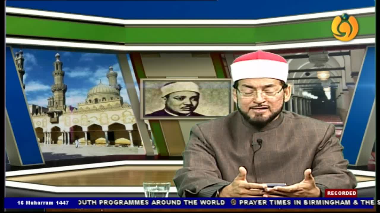 A man in a suit and a white cap with a red top is speaking, gesturing with his hands. Behind him, a screen displays a portrait and images of a mosque.

