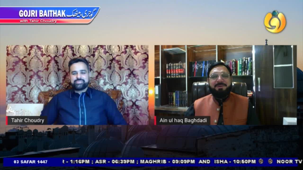Two men are seated, each in their own frame, on a broadcast from Noor TV in the United Kingdom. Tahir Choudry, in a dark blue shirt, sits in front of a patterned wall, while Ain ul haq Baghdadi, wearing glasses and a vest, is in a room with a bookshelf.

