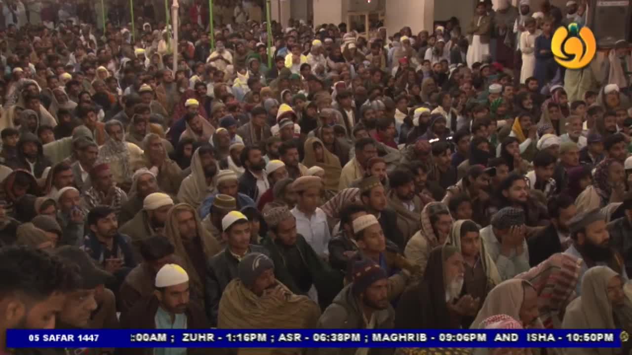 A large crowd of men, many wearing hats and head coverings, are seated close together. The Noor TV logo is visible in the corner, and the time is displayed at the bottom of the screen.
