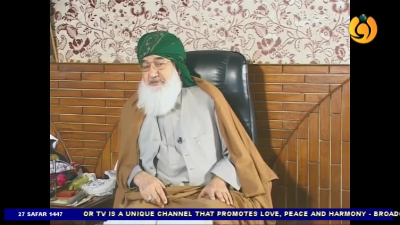 A man in a green turban and white beard sits in a chair, facing the camera. The Noor TV logo is visible in the corner, and a banner at the bottom promotes the channel's message.
