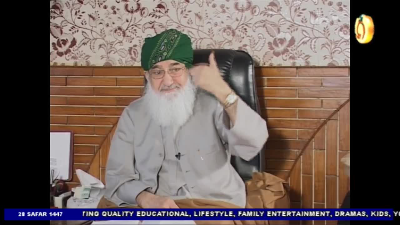 A man wearing a green turban and glasses sits in a chair, giving a thumbs-up. The Noor TV logo is visible in the corner, and the lower third of the screen displays text.

