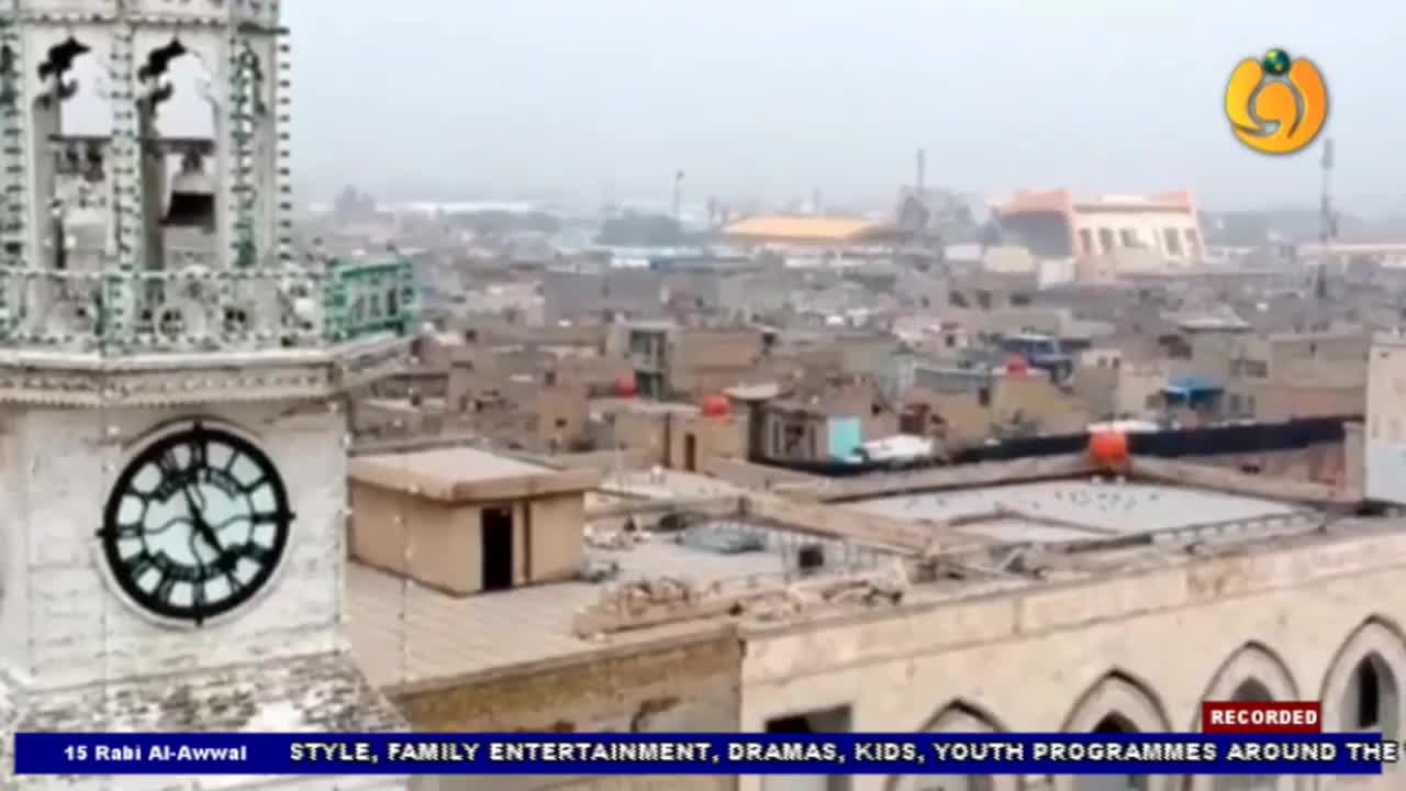 A clock tower stands tall, its hands nearing 11 o'clock, overlooking a dense cityscape. The Noor TV logo is visible in the corner, broadcasting from the United Kingdom.
