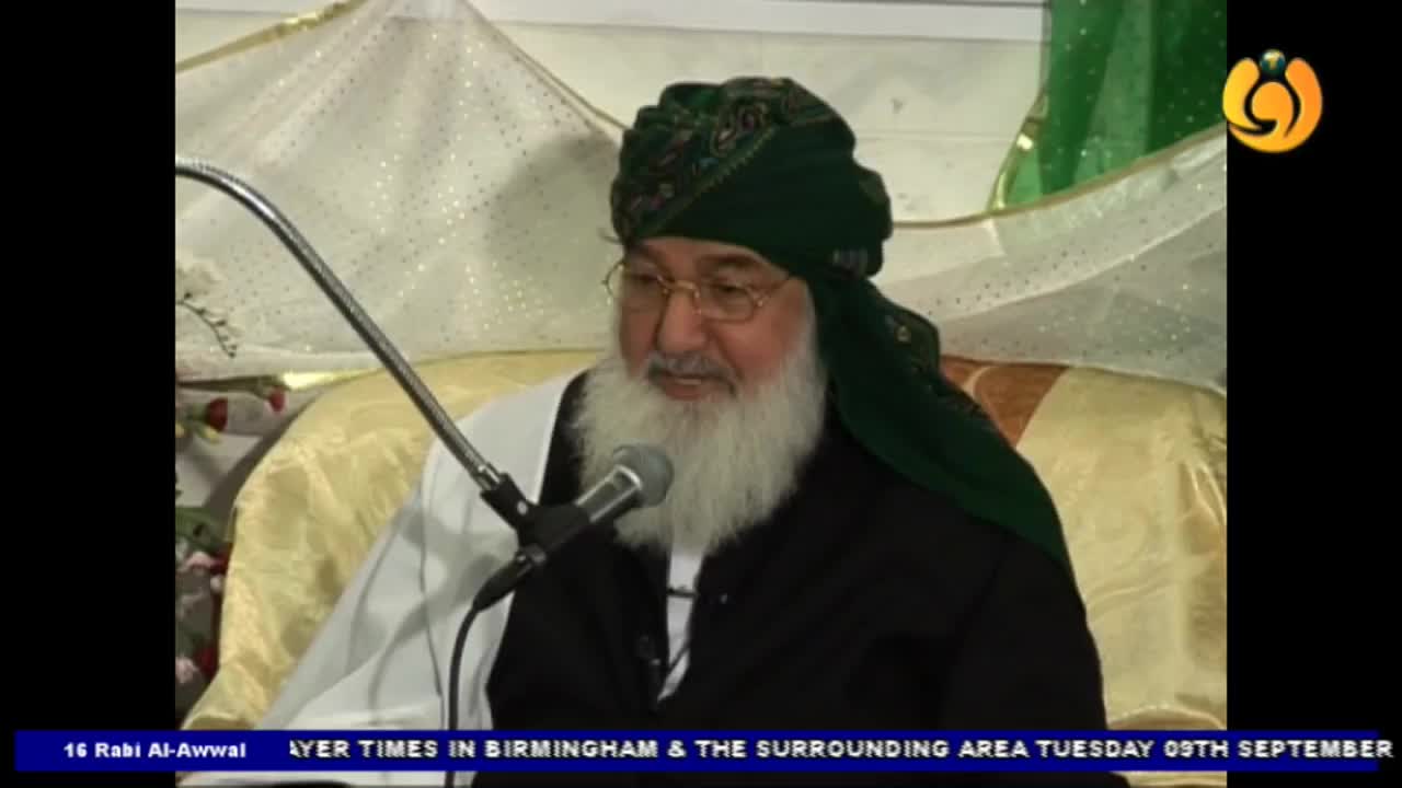 A man with a long white beard and a green turban speaks into a microphone. The Noor TV logo is visible in the corner, and the lower third of the screen displays text about Birmingham.
