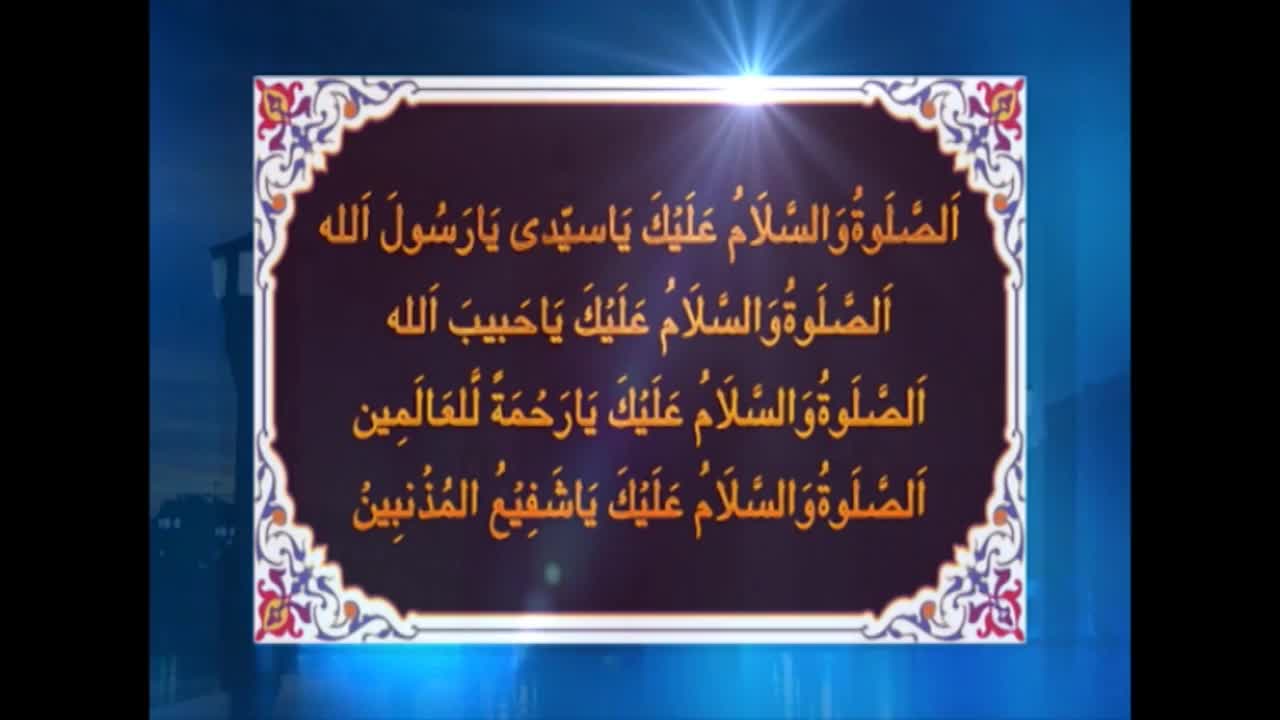 A screen displays Arabic script in a decorative frame, likely from a broadcast on Noor TV in the United Kingdom. The words are illuminated by a bright light emanating from the top of the screen.
