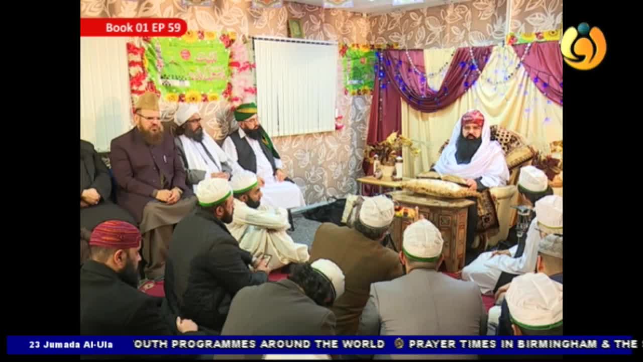 A man in a white robe and turban sits behind a small table, speaking to a group of men seated on the floor. The scene appears to be broadcast on Noor TV, with text at the bottom indicating the program is from the United Kingdom.
A man in a white robe and turban sits behind a small table, speaking to a group of men seated on the floor. The scene appears to be broadcast on Noor TV, with text at the bottom indicating the program is from the United Kingdom.