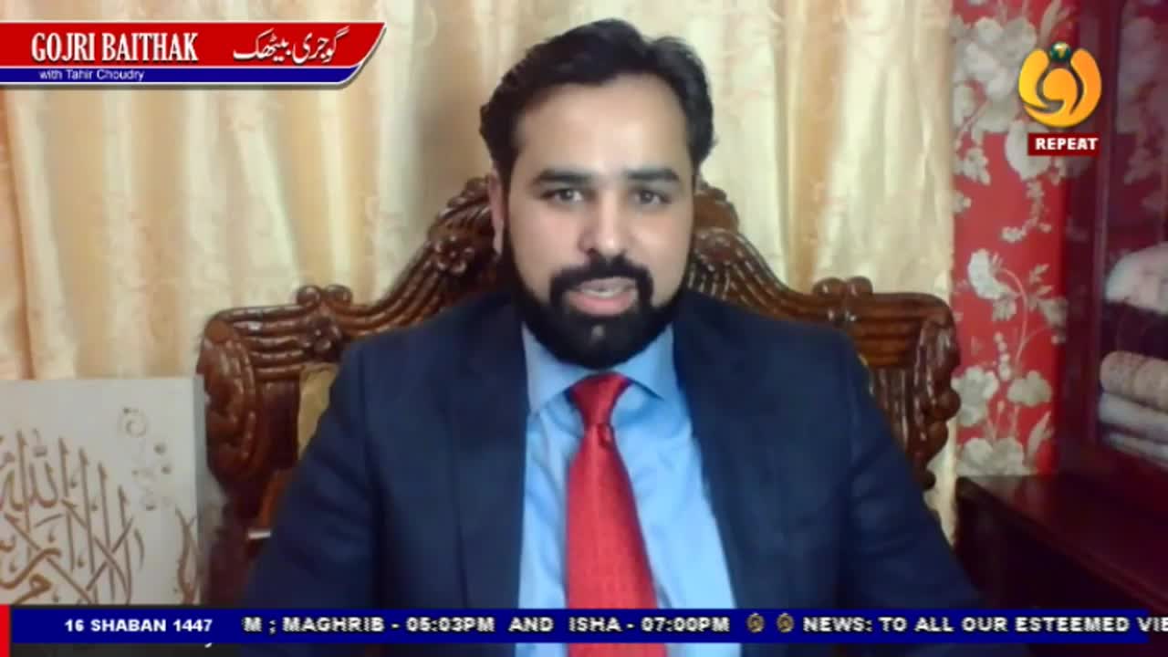 A man in a dark suit and red tie speaks from an ornate chair. A graphic at the top left indicates this is "Gojri Baithak with Tahir Choudhry" on Noor TV.