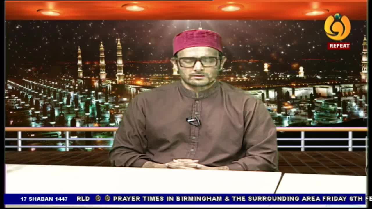 A man in a maroon cap and brown tunic sits with his eyes closed, hands clasped. The backdrop behind him displays a nighttime cityscape with illuminated minarets, suggesting a broadcast from Noor TV.